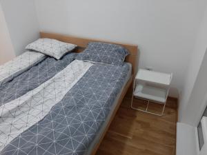 a small bedroom with two beds and a table at Oaza Apartment Mirijevo, Free Garage Parking in Belgrade