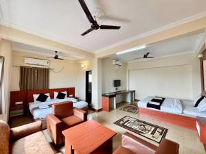 a hotel room with two beds and a couch at Hotel Subham Beach inn ! PURI near-sea-beach-and-temple fully-air-conditioned-hotel with-lift-and-parking-facility in Puri