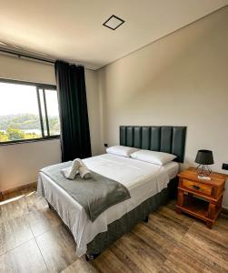 - une chambre avec un grand lit et une fenêtre dans l'établissement Pousada Villa Shalom, à Igaratá
