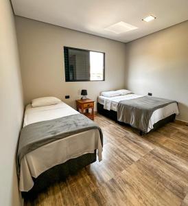 a room with two beds and a window at Pousada Villa Shalom in Igaratá +42 photos