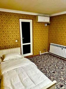 um quarto com uma cama grande e uma janela em Aisha Guest House em Samarkand