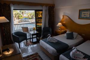 a hotel room with two beds and a balcony at Turquoise Beach Hotel in Sharm El Sheikh