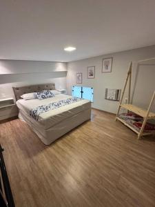 a bedroom with a bed and a wooden floor at Apartamento/Loft 06 em Cabo Frio in Cabo Frio