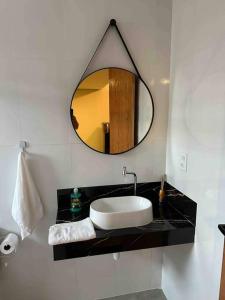 a bathroom with a sink and a mirror at Apartamento/Loft 06 em Cabo Frio in Cabo Frio