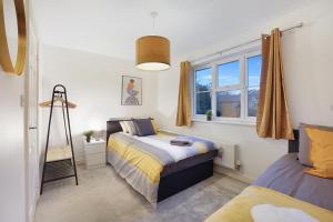 a bedroom with two beds and a window at Comfortable stylish Townhouse in Ashford sleeps 5 Netflix 2 Parking spaces Perfect for Contractors and Families in Ashford