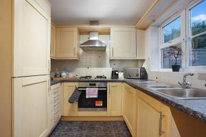 a kitchen with a sink and a stove top oven at Comfortable stylish Townhouse in Ashford sleeps 5 Netflix 2 Parking spaces Perfect for Contractors and Families in Ashford