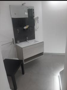 La salle de bains blanche est pourvue d'un lavabo et d'un miroir. dans l'établissement B&B Etnea Palace, à Catane