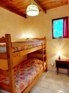 Village de gîtes La Fontinelle في Bessas: غرفة نوم بسريرين بطابقين وطاولة