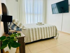 a bedroom with a bed and a tv on a wall at Moderno y Nuevo Departamento Parque Saavedra La Plata in La Plata