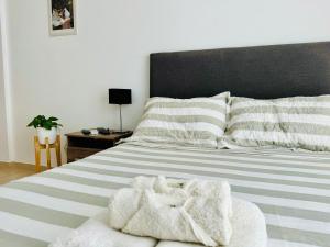 a bedroom with a bed with a black headboard and white sheets at Moderno y Nuevo Departamento Parque Saavedra La Plata in La Plata
