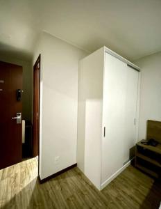 Habitación con un gran armario blanco y suelo de madera. en Suíte Master - com vista panorâmica!!!, en Río de Janeiro
