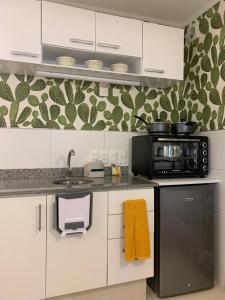 a kitchen with a stove and a microwave at Completo Monoambiente de Montevideo Bliss in Montevideo
