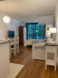 Habitación blanca con cama y escritorio en Completo Monoambiente de Montevideo Bliss, en Montevideo