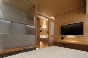 a bedroom with a bed and a flat screen tv at KOYADO HOTEL Adult only in Tokyo