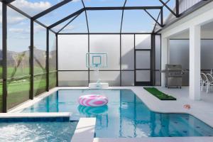 a swimming pool in a house with a glass wall at Villatel Orlando Resort in Orlando
