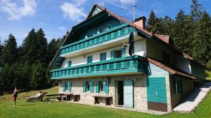 Una donna in piedi davanti a una casa di Apartma Jurček Rogla a Rakovec