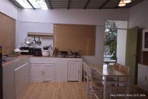 a kitchen with white cabinets and a table with chairs at Pharungruang House Thatphanom Nakonphanom พารุ่งเรืองเฮ้าส์ in That Phanom