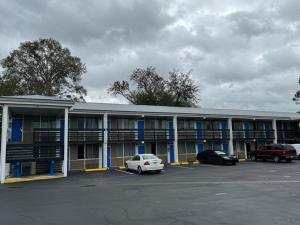 a building with cars parked in a parking lot at Midtown Lodge in Jacksonville