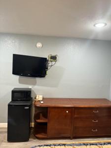 a room with a television on a wall with a desk at Midtown Lodge in Jacksonville