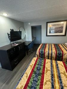 a hotel room with two beds and a flat screen tv at Midtown Lodge in Jacksonville