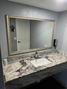 a bathroom with a sink and a large mirror at Midtown Lodge in Jacksonville