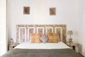 sypialnia z białym łóżkiem i kolorowymi poduszkami w obiekcie Lanui Guest House w mieście Sintra