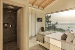 sypialnia z łóżkiem i dużym szklanym oknem w obiekcie Luxury Villa Mon I Vassilikos w mieście Vasilikos