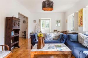 sala de estar con sofá azul y mesa en Lanui Guest House, en Sintra