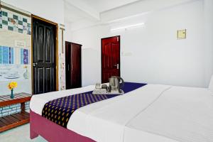 a bedroom with a white bed and a red door at SPOT ON Cherai Homes in Cherai Beach