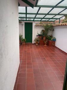 a patio with a green door and potted plants at Hostal Villa Carmen in Villa de Leyva