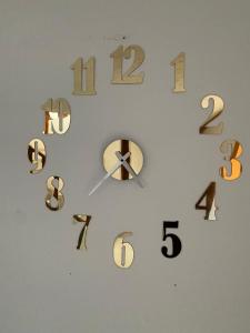 a clock on a wall with numbers on it at Hostal Villa Carmen in Villa de Leyva