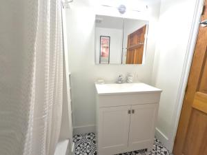 een badkamer met een witte wastafel en een spiegel bij Superb 3 Bed Apartment 3mins From Mont-Royal Metro in Montreal