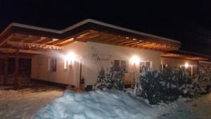 ein Haus in der Nacht mit Schnee davor in der Unterkunft Apart Lechtraum in Stanzach