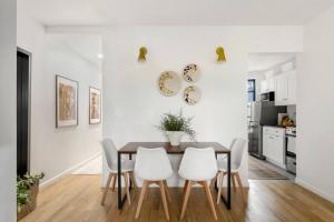 a dining room with a table and white chairs at Bright Designer Cottage in Historic Harlem in New York