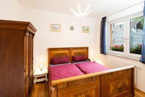 ein Schlafzimmer mit einem großen Holzbett mit violetter Bettwäsche in der Unterkunft Ferienhof Obertor in Kirchberg an der Murr