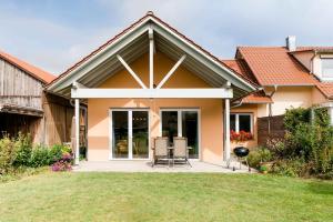 ein Haus mit Stühlen und einem Grill im Hof in der Unterkunft Ferienhof Obertor in Kirchberg an der Murr