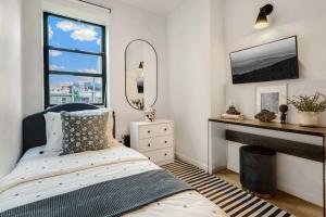 sypialnia z łóżkiem, kominkiem i lustrem w obiekcie Bright Designer Cottage in Historic Harlem w Nowym Jorku