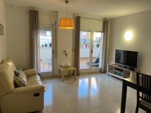 uma sala de estar com um sofá e uma televisão em Còmode apartament al bell mig de Girona em Girona