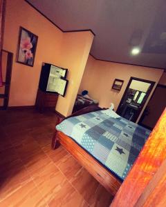 1 dormitorio con 1 cama y TV en Ceiba lodge, en Drake