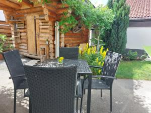 una mesa y sillas al aire libre frente a una cabaña en Apart Lechtraum, en Stanzach