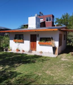 una casa blanca con plantas en las ventanas en Cabaña Los Algarrobos, en Villa Icho Cruz 34 fotos más