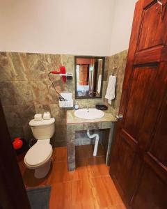 a bathroom with a toilet and a sink at Ceiba lodge in Drake