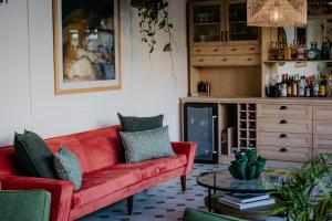 een woonkamer met een rode bank en een tafel bij Fancy Fritz B&B in Swakopmund