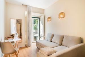 ein Wohnzimmer mit einem Sofa und einem Tisch in der Unterkunft Metropolitan Living Lisbon - Laranjeiras in Lissabon