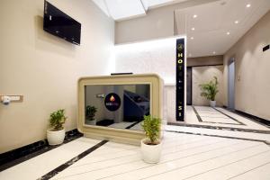 a large tv in a lobby with two potted plants at Aceotel Select Tulsi Vijay Nagar- A Luxury Boutique Hotel in Indore