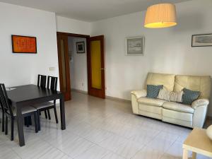 ein Wohnzimmer mit einem Sofa und einem Tisch in der Unterkunft Còmode apartament al bell mig de Girona in Girona