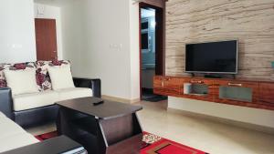 un soggiorno con TV e divano di SOLACE Premium 2BHK Apartment near Manyata Tech Park And Hebbal a Bangalore