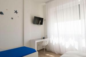 a bedroom with a bed and a tv and a window at estea in Castellaneta Marina