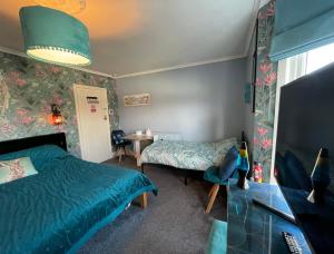 a bedroom with a bed and a desk and a table at Large Room sleeps 3 own TV and cereal and toast breakfast in Newhaven in Tarring Neville