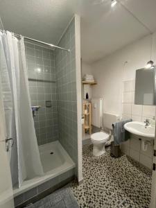 a bathroom with a tub and a toilet and a sink at JonnysSleepOver in Osnabrück
